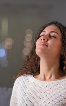 a woman is sitting on a couch with her eyes closed .